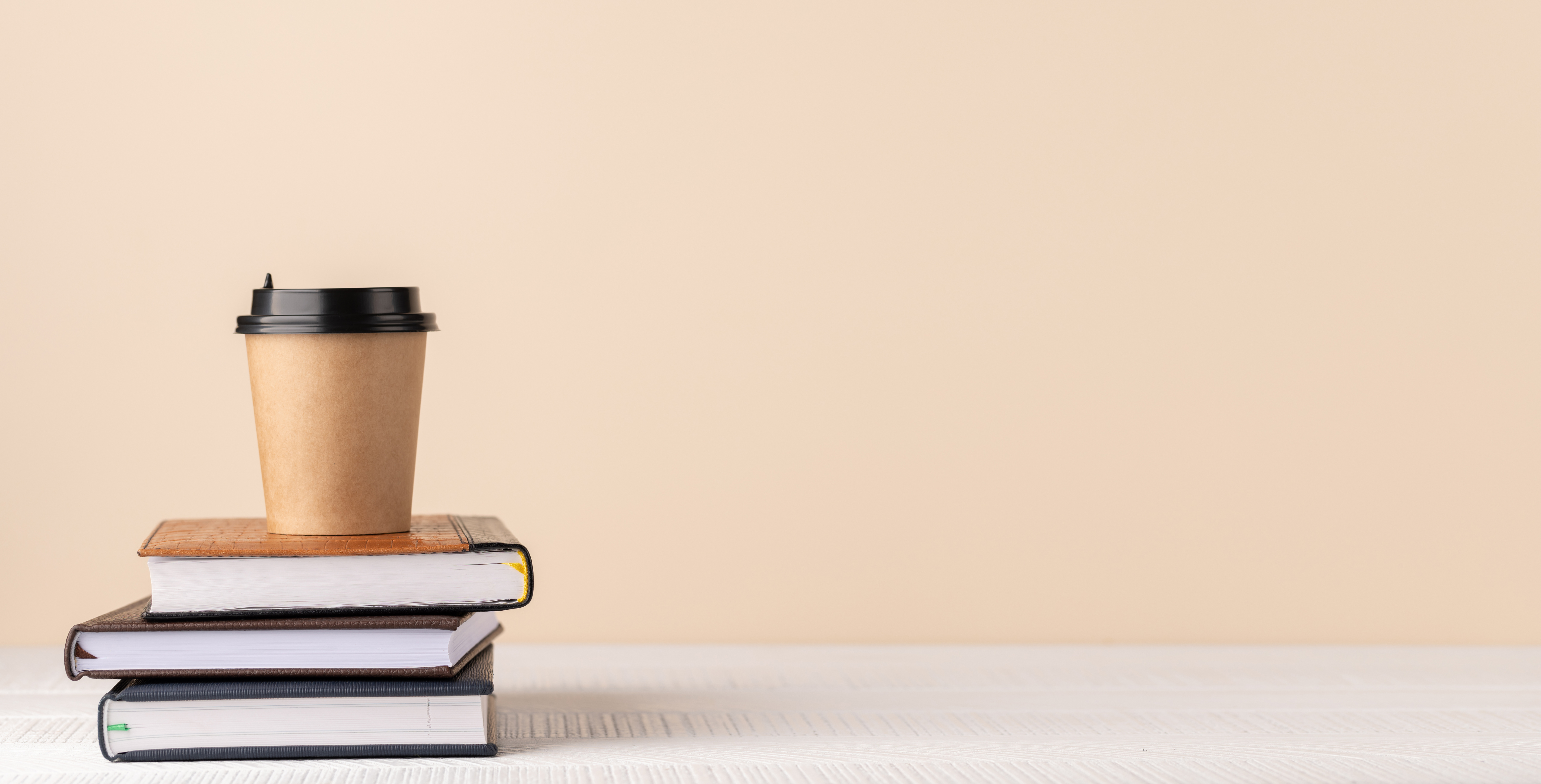 Coffee cup on stack of notepads